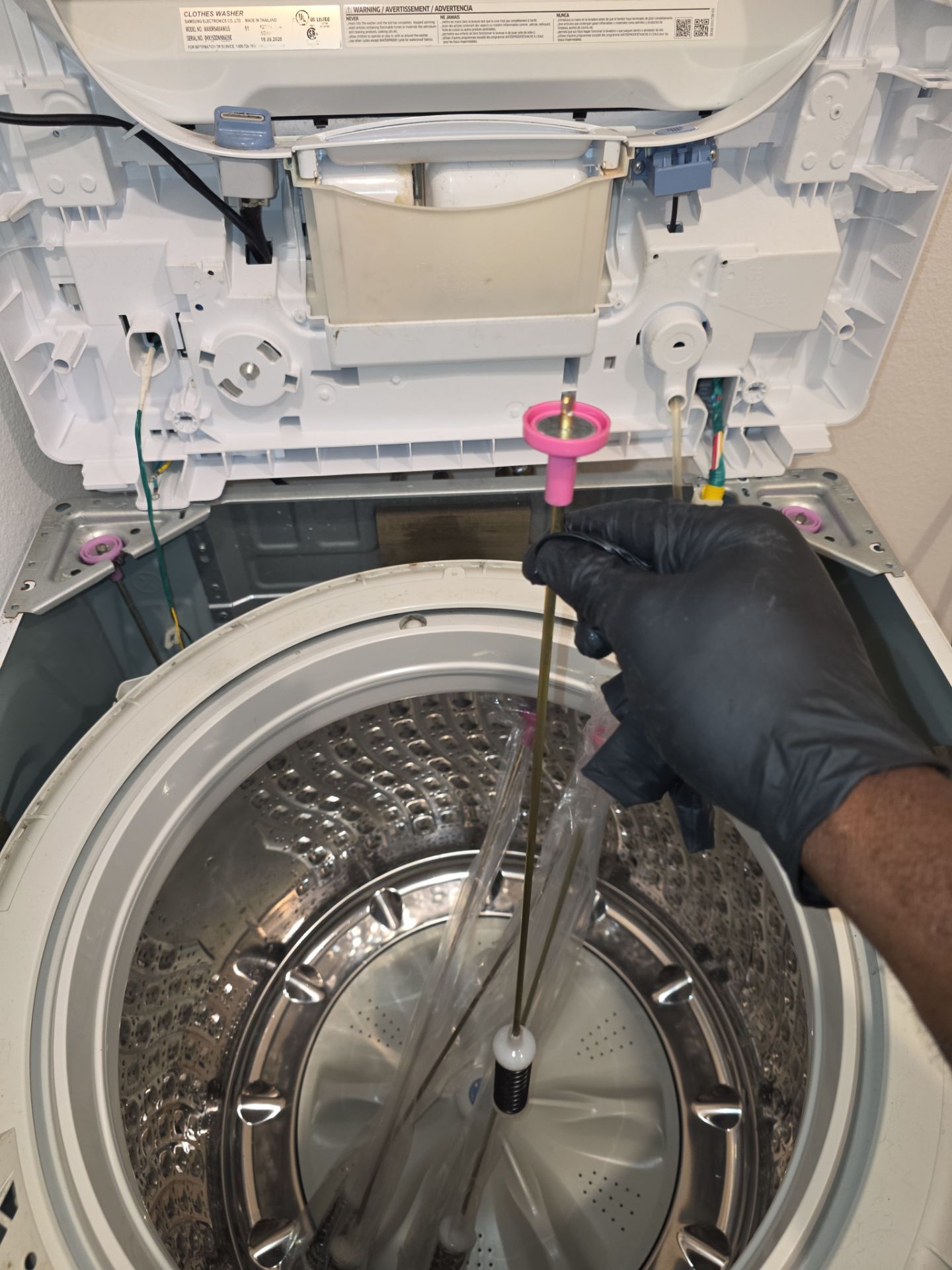 AMB Works technician replacing Samsung washer suspension rod to fix UE error code